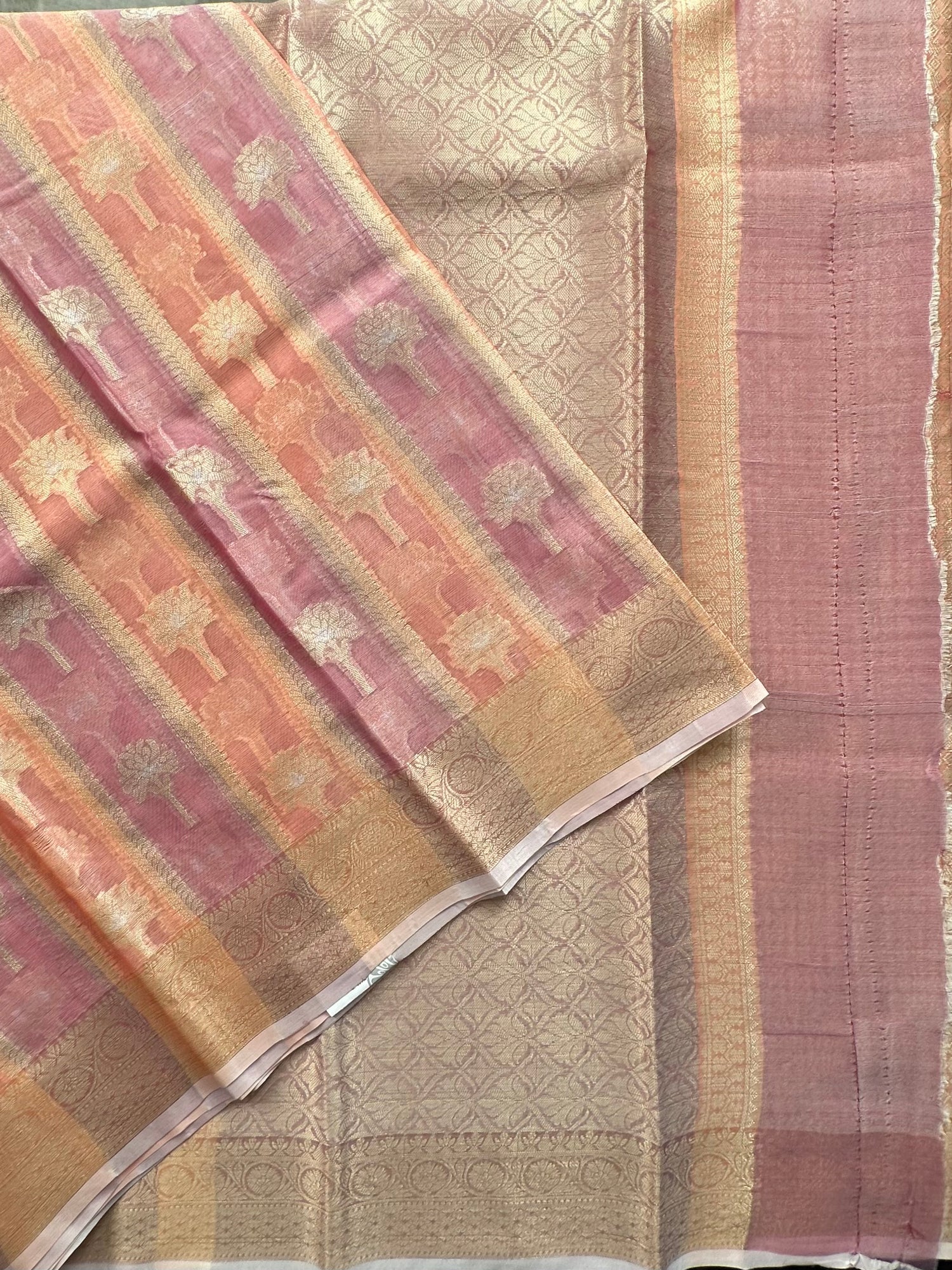 Textured fabric with pink, beige, and gold patterns